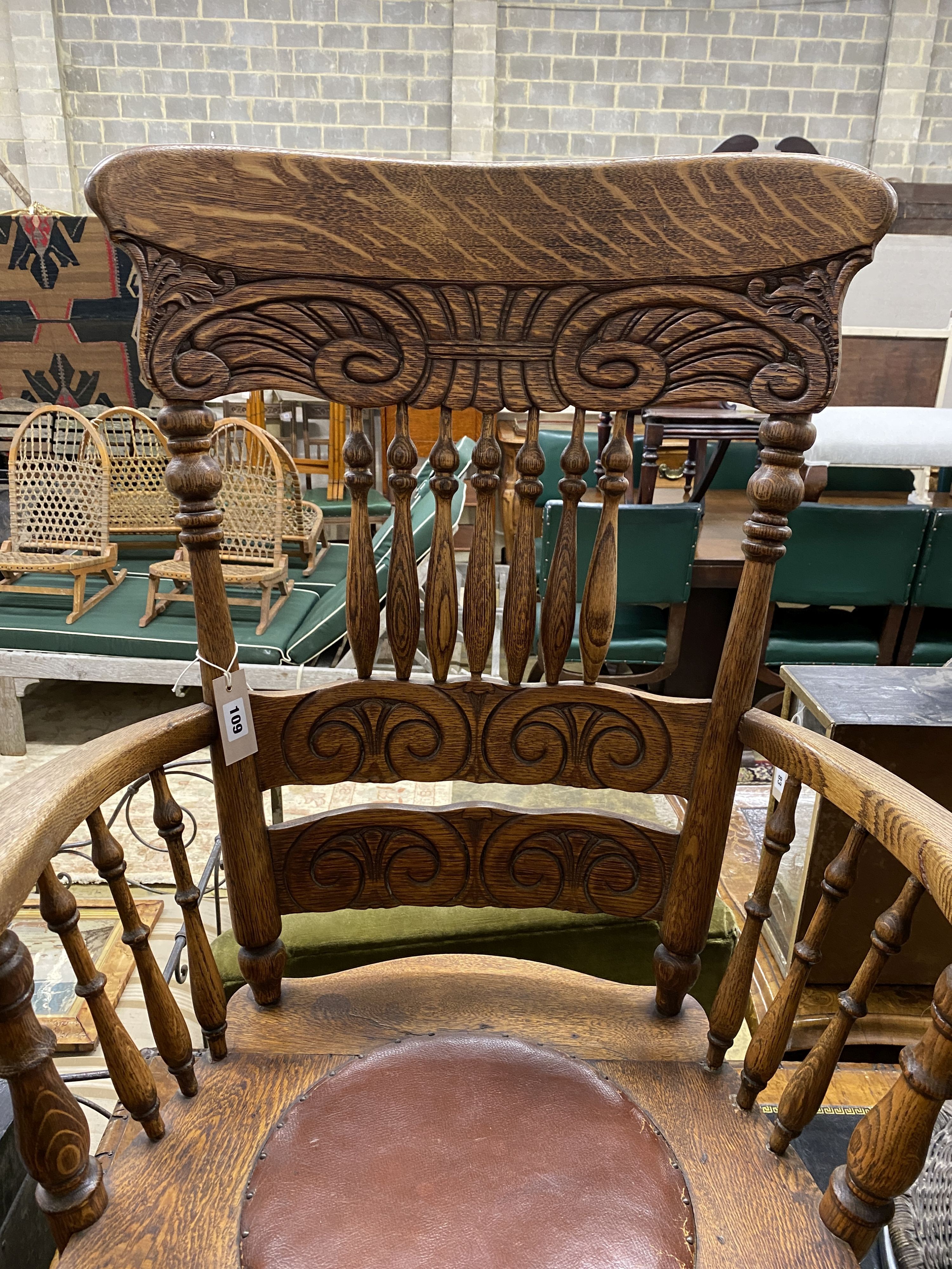 An early 20th century oak low seat elbow chair, width 75cm, depth 48cm, height 97cm